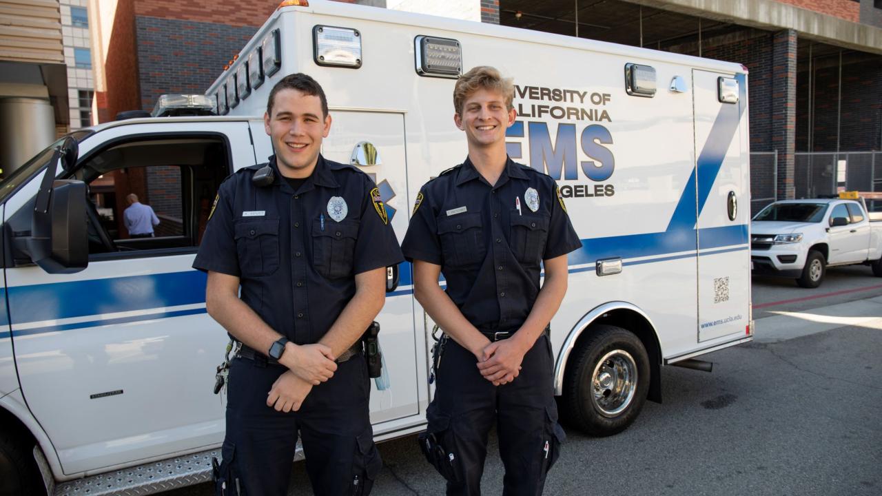 Two EMTs standing in front of an ambulance